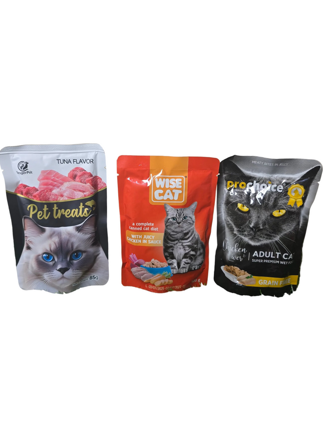 Three cat food packages on a grassy surface with a beige wall background